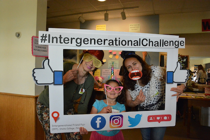 Three people pose for a photo with silly props