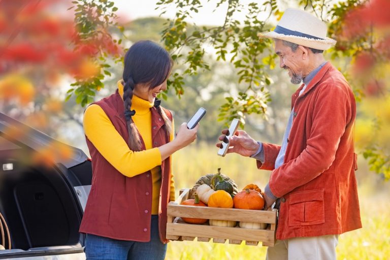 two people engaging in a sales transaction with the help of a smartphone